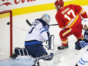 The Calgary Flames' Lance Bouma scores on Winnipeg Jets goaltender Connor Hellebuyck during the third period of NHL action at the Scotiabank Saddledome in Calgary on Saturday December 10, 2016.