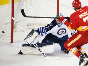Calgary Flames TJ Brodie comes close to scoring on Winnipeg Jets goaltender Connor Hellebuyck during the third period of NHL action at the Scotiabank Saddledome in Calgary on Saturday December 10, 2016.