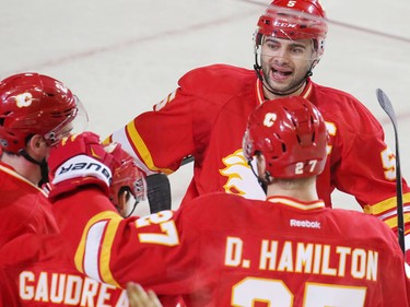 Calgary Flames captain Mark Giordano skates into celebrate with teammates after Sean Monahan scored on Winnipeg Jets goaltender Connor Hellebuyck during the third period of NHL action at the Scotiabank Saddledome in Calgary on Dec. 10, 2016.