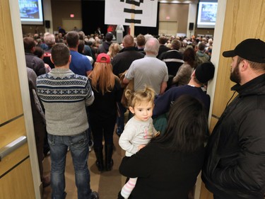 Aria Straczek, 18 months, is held by her mom as they watch with a packed crowd listening to Ezra Levant speak during Rebel Media's anti carbon tax rally held at the Westin Hotel in Calgary on Sunday December 11, 2016.