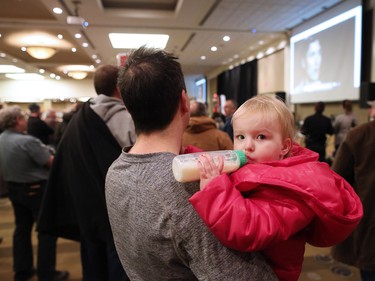 Claire Bothwell, 2, is held by her dad as he watches with along with a packed ballroom at an anti carbon tax rally held at the Westin Hotel in Calgary on Sunday December 11, 2016.