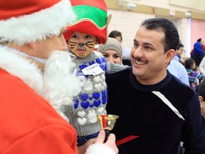 Syrian families react to seeing Santa Claus arrive at the Syrian Kids Christmas Party at the Marlborough Park Community Centre on Sunday December 11, 2016.  GAVIN YOUNG/POSTMEDIA