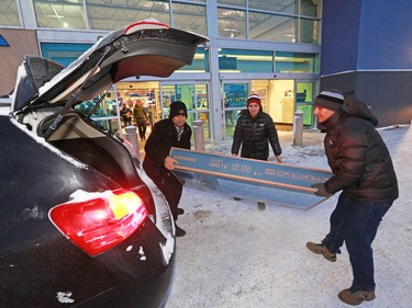 The Kfle family loads a new TV outside Best Buy in Sunridge, left after a Boxing Day sale on December 26, 2016.