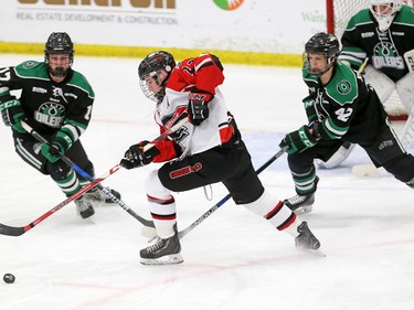 The CFR Chemical Bisons' Kaden Hanas scrambles for the puck between Alaska Oilers players Cam McDonald, left and Logan Rachow during their Mac's Midget Hockey Tournament game at the Max Bell Arenas on Tuesday December 27, 2016.