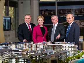 In front of a model displaying Westman Village, Larry Noer, executive vice-president of Jayman Built Multi-Family, Lisa Feist, vice-president of sales and marketing for Jayman Built Multi-Family, Jay Westman, chairman and CEO of Jayman Built, and Wallace Chow, vice-president of development for Jayman Built Multi-Family.