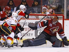 Calgary Flames center Mikael Backlund (11) scores a goal against Arizona Coyotes goalie Mike Smith (41) as Flames center Sam Bennett (93) creates a screen during the second period of an NHL hockey game Monday, Dec. 19, 2016, in Glendale, Ariz.