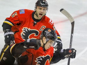 Calgary Flames Johnny Gaudreau celebrates his goal with Flames Mark Giordano against Anaheim Ducks goalie Jonathan Bernier for the Flames first goal in NHL hockey action at the Scotiabank Saddledome in Calgary, Alta. on Sunday December 4, 2016. Mike Drew/Postmedia