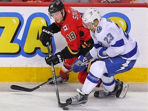 Calgary Flames Matt Stajan and J.T. Brown of the Tampa Bay Lightning battle for a loose puck during NHL hockey in Calgary, Alta. on Tuesday January 5, 2016. Al Charest/Calgary Sun/Postmedia Network