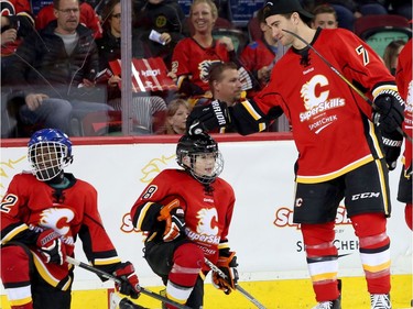 Calgary Flames TJ Brodie congratulates a peewee hockey players goal during the Flames SuperSkills at the Scotiabank Saddledomein Calgary, Alta., on Saturday December 3, 2016. Leah Hennel/Postmedia