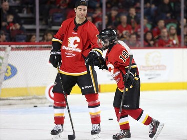 Calgary Flames TJ Brodie congratulates a peewee hockey players goal during the Flames SuperSkills at the Scotiabank Saddledomein Calgary, Alta., on Saturday December 3, 2016. Leah Hennel/Postmedia