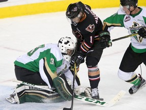 Calgary Hitmen Beck Malenstyn, middle, tries to score on Prince Alberta Raiders Ian Scott, left, in WHL action at the Scotiabank Saddledome in Calgary on Sunday, October 23, 2016.