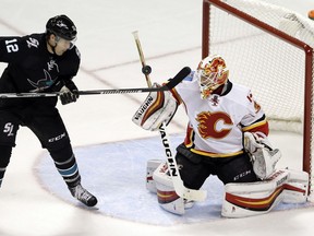 Calgary Flames goalie Chad Johnson, right, deflects a shot next to San Jose Sharks' Patrick Marleau during the third period of an NHL hockey game Thursday, Nov. 3, 2016, in San Jose, Calif. Calgary won 3-2.