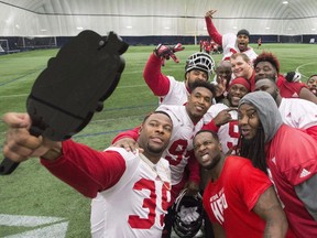 Calgary Stampeders defensive lineman Charleston Hughes (left) takes a group selfie with teammates during Grey Cup week in Toronto on Friday, November 25, 2016. Defensive end Hughes signed a two-year contract extension with the Calgary Stampeders last week. (The Canadian Press)