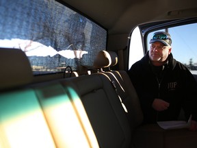 Chris Stoski looks at his damaged back window of his truck after it was shot out from a suspected road rage incident in Calgary, Alta., on Saturday December 17, 2016. Leah Hennel/Postmedia