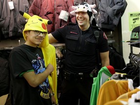Constable Steve MacKenzie shares a fun moment with Noor Al-Fatlawi, 14, during the 11th annual CopShop event at Marlborough Mall in Calgary, Alta., on Wednesday December 7, 2016. The event pairs up officers with 27 local students for a shopping spree. Leah Hennel/Postmedia