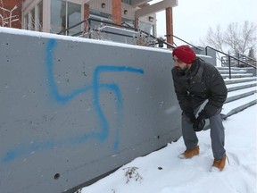 Harpeet Singh Gill, a volunteer at the Sikh Society Temple, examines vandalism on the outside of the building.