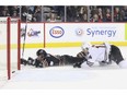 Calgary Hitmen Beck Malenstyn slides passed the net after dekeing by the Red Deer Rebels goalie Lasse Petersen to score the winning overtime goal in Calgary, on December 9, 2016. (Crystal Schick/Independent)
