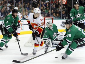 Calgary Flames forward Johnny Gaudreau passes the puck amid pressure from the Dallas Stars during a recent game in Texas. (AP photo)