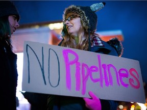 Julie Dujardin holds a sign during a protest against the Kinder Morgan Trans Mountain Pipeline expansion project, in Vancouver, B.C. Prime Minister Justin Trudeau approved the $6.8-billion project last month.