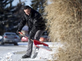 Snow Angels program coordinator Geoff Moore clears snow from a sidewalk for a staged photo outside of the City's Georgina Thomson Building in Calgary, Alta., on Wednesday, Dec. 7, 2016. The Snow Angels program urges people to help keep walks clear of snow and ice for seniors and others with mobility challenges. Lyle Aspinall/Postmedia Network
