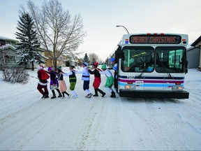 Volunteers from the Magic of Christmas leave a bus to deliver donated gifts to a family in need. Photo courtesy Calgary Transit