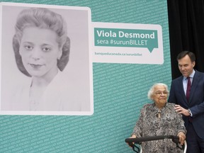 Minister of Finance Bill Morneau puts his hand on the shoulder of Wanda Robson, the sister of Viola Desmond, as it is announced Desmond will be featured on Canadian currency during a ceremony in Gatineau, Quebec on Thursday December 8, 2016.