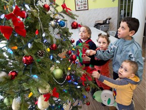 New Syrian refugees from left: Fatima, 5, Khadja, 4, Abdul Karam, 7, and Mohammad, 3, check out the Christmas tree at the Calgary Catholic Immigration Society on Monday, December 12, 2016. The siblings and their parents Abdullatif and Ebtisan Alawa escaped from Aleppo in 2013 and have been bounced around several countries in the Middle East always with the hope of making it to Canada. They arrived in late November.