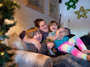 Ayla Tennant hugs her two children David, 6, and Amelia, 2 at home in Calgary on Dec. 7, 2016. The family have been helped by CUPS, one of the recipients of the 2016 Calgary Herald Christmas Fund.
