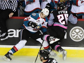 Kelowna Rockets forward Nick Merkley gets clipped by Calgary Hitmen forward Andrew Fyten in front of the bench at the Scotia Bank Saddledome on Dec. 17. (Ryan McLeod)