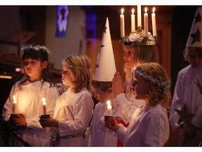 FILE PHOTO Sunday December 15, 2013 — This year's Lucia with her crown of candles, Sofia de Cuba, sings with other girls at St. John Lutheran Church.