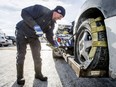 Neal Joad, an AMA service vehicle operator, secures a minivan to his tow truck outside of the Marlborough Canadian Tire in Calgary, Alta., on Monday, Dec. 12, 2016. He's working what is considered to be one of the worst cold-weather jobs.