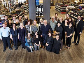Owner Wayne Henuset, leaning on barrel at centre, and the staff at the recently renovated Willow Park Wines & Spirits main store.