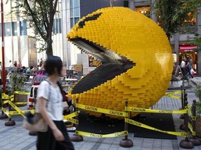 FILE - In this Aug. 12, 2015, file photo, a woman walks past a three-meter (nine-foot)-tall Pac-Man made of Lego bricks, in Tokyo&#039;s Shinjuku area. Masaya Nakamura, the &ampquot;Father of Pac-Man&ampquot; who founded the Japanese video game company behind the hit creature-gobbling game, has died on Jan. 22, 2017, at age 91, the company Bandai Namco said. (AP Photo/Ken Aragaki, File)