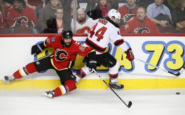 New Jersey Devils Miles Wood, right, collides with Calgary Flames Deryk Engelland in NHL hockey action at the Scotiabank Saddledome in Calgary, Alta. on Friday January 13, 2017. Leah Hennel/Postmedia