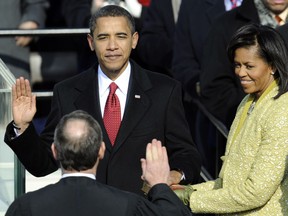 FILE PHOTO: Barack Obama is sworn in as the 44th US president by Supreme Court Chief Justice John Roberts in front of the Capitol in Washington on January 20, 2009. Michelle Obama (R) holds the Lincoln Bible.