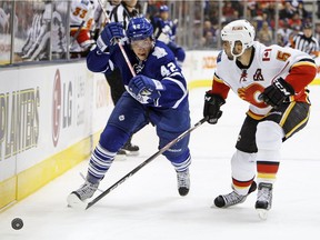 Tyler Bozak of the Toronto Maple Leafs gets around Mark Giordano of the Calgary Flames at the Air Canada Centre in Toronto on Oct. 15, 2014. (File)