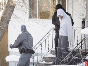 A male is escorted by police out of home on Stanley Rd SW in Calgary, Alta., on Thursday, Jan. 12, 2017. Police arrested a man after a lengthy stand-off following an EMS worker being hurt while responding to a medical call at the home. Lyle Aspinall/Postmedia Network
