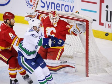 Calgary Flames goaltender Chad Johnson reaches out ro grab the puck during this Vancouver Canucks scoring chance during NHL action at the Scotiabank Saddledome in Calgary on Saturday January 7, 2017.