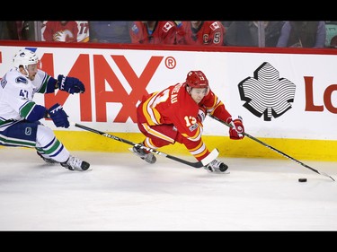The Calgary Flames' Johnny Gaudreau is chased down the boards by the Vancouver Canucks' Sven Baertschi during NHL action at the Scotiabank Saddledome in Calgary on Saturday January 7, 2017.