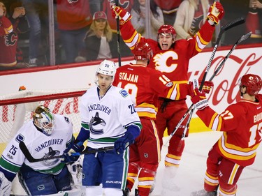The Calgary Flames celebrate Matt Stajan's goal on Vancouver Canucks goaltender Jacob Markstrom during NHL action at the Scotiabank Saddledome in Calgary on Saturday January 7, 2017.