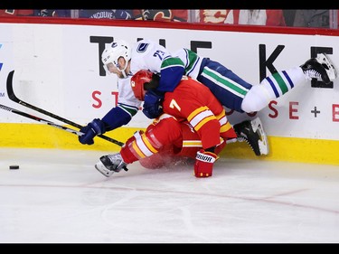 Vancouver Canucks defenceman Alexander Edler piles on top of the Calgary Flames' TJ Brodie during NHL action at the Scotiabank Saddledome in Calgary on Saturday January 7, 2017.