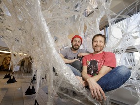 Artists Jeremy Gordaneer (L) and Peter Trosztmer pose for a photo inside their Boxtape art installation in the Plus 15 over Stephen Avenue between Bankers Hall and the Core shopping centre in downtown Calgary, Alta., on Thursday, Jan. 26, 2017. The temporary interactive performance piece is part of the High Performance Rodeo. Lyle Aspinall/Postmedia Network