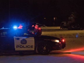 Police talk to a neighbourhood resident at a road block on Whitlock Close N.E. after a reported stabbing nearby on Tuesday evening, January 10, 2017.