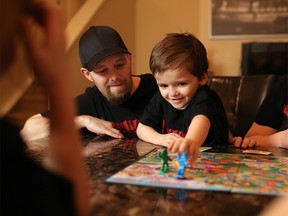 Journey Dickson, 6, plays a board game with his family including dad Doug on Sunday January 15, 2017. Both Doug and Journey suffer from a rare blood disorder that requires many hospital and other medical trips a month. The struggling family has started a GoFundMe campaign to raise money for a new vehicle. GAVIN YOUNG/POSTMEDIA