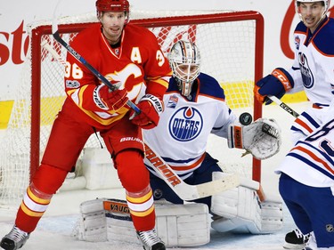 Calgary Flames forward Troy Brouwer and Edmonton Oilers goaltender Laurent Broissoit watch the bouncing puck during NHL action at the Scotiabank Saddledome in Calgary on Saturday January 21, 2017.