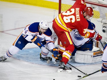 Calgary Flames forward Troy Brouwer and the Edmonton Oilers' Kris Russell angle for a loose puck in front of  Edmonton Oilers goaltender Laurent Broissoit during second period NHL action at the Scotiabank Saddledome in Calgary on Saturday January 21, 2017.