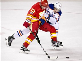 The Calgary Flames' Johnny Gaudreau and the Edmonton Oilers' Matt Benning battle for the puck during NHL action at the Scotiabank Saddledome in Calgary on Saturday January 21, 2017.