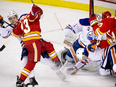 The Calgary Flames' Johnny Gaudreau and the Edmonton Oilers' Matt Benning battle, left, battle for position in front of the Oilers net during NHL action at the Scotiabank Saddledome in Calgary on Saturday January 21, 2017.