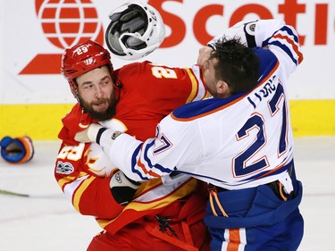 Edmonton Oilers forward Milan Lucic's helmet flies off as he fights the Calgary Flames' Deryk Engelland during NHL action at the Scotiabank Saddledome in Calgary on Saturday January 21, 2017.