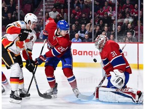 Goaltender Carey Price #31 of the Montreal Canadiens makes a save near teammate Nathan Beaulieu #28 and Sean Monahan #23 of the Calgary Flames during the NHL game at the Bell Centre on January 24, 2017 in Montreal.